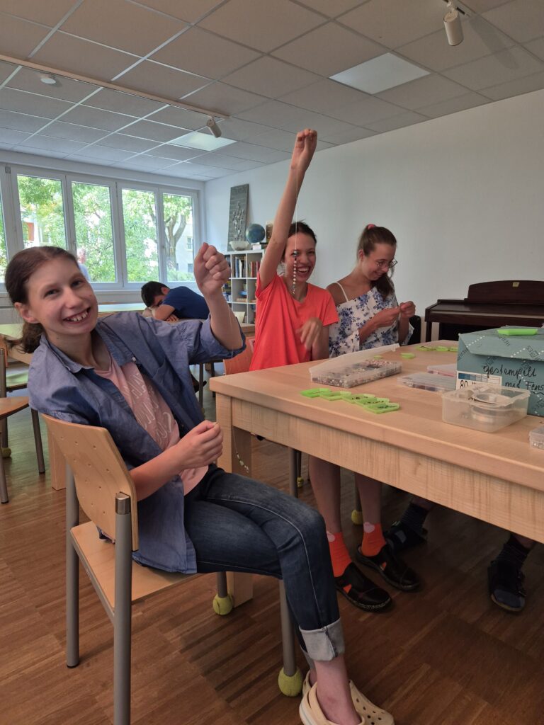 Klientinnen der Produktegruppe präsentieren Perlenketten.