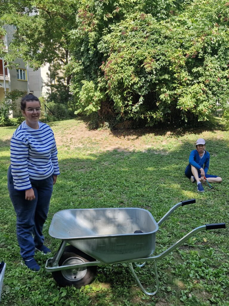 Klientin neben einer Schreibtruhe im Garten.