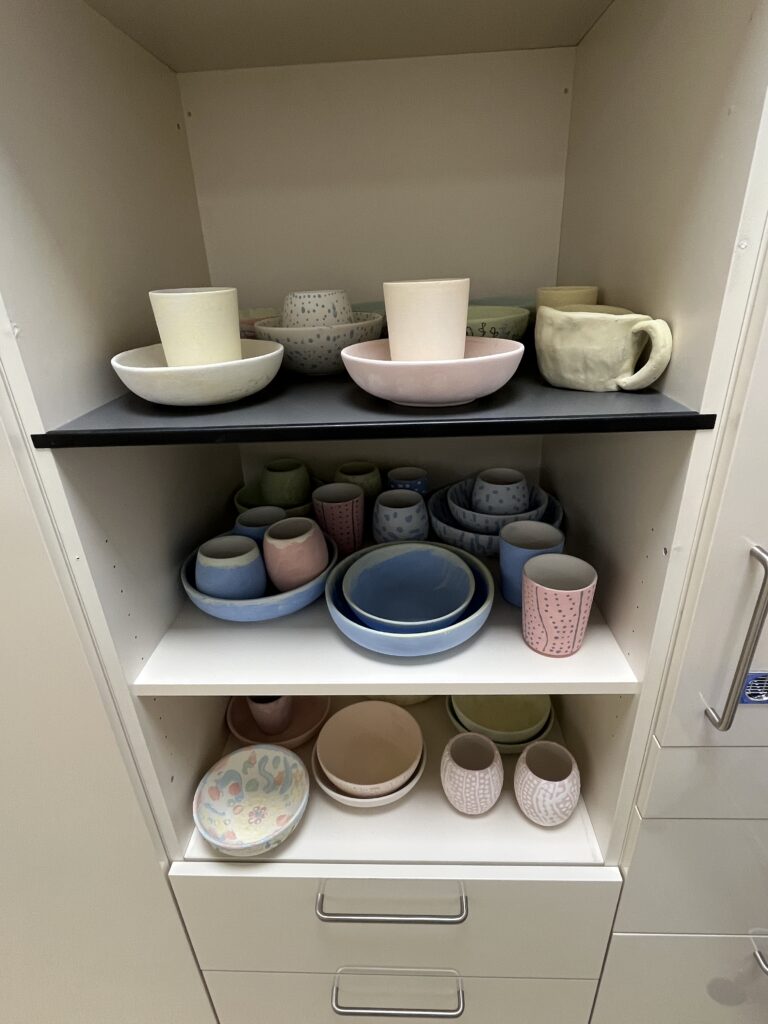 Kasten mit selbst bemaltem Keramikgeschirr.